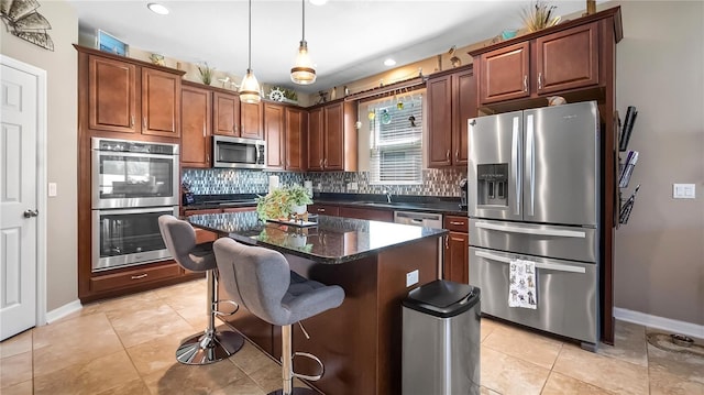 kitchen featuring a breakfast bar area, stainless steel appliances, a kitchen island, backsplash, and decorative light fixtures