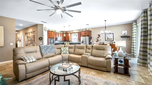 26747 White Plains Way, Leesburg, FL 34748 - living area featuring baseboards, visible vents, ceiling fan with notable chandelier, and light tile patterned flooring