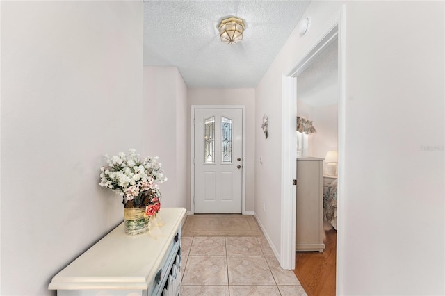 1202 San Bernardo Rd, The Villages, FL 32162 - entryway with a textured ceiling, light tile patterned floors, and baseboards