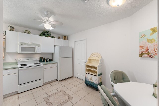 1202 San Bernardo Rd, The Villages, FL 32162 - kitchen with light tile patterned floors, white appliances, a ceiling fan, white cabinets, and light countertops