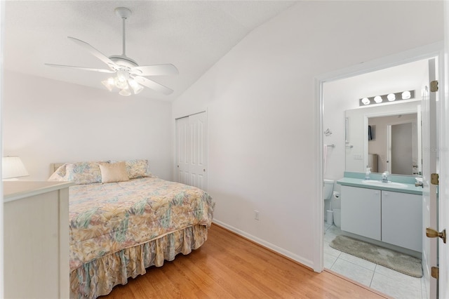 1202 San Bernardo Rd, The Villages, FL 32162 - bedroom with ensuite bathroom, a sink, vaulted ceiling, a closet, and light wood-type flooring