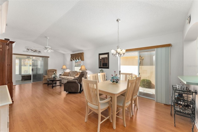 1202 San Bernardo Rd, The Villages, FL 32162 - dining area featuring light wood-style flooring, vaulted ceiling, a textured ceiling, and ceiling fan with notable chandelier