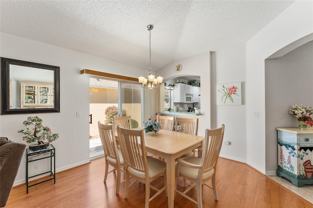 1202 San Bernardo Rd, The Villages, FL 32162 - dining area with a textured ceiling, light wood finished floors, baseboards, and an inviting chandelier