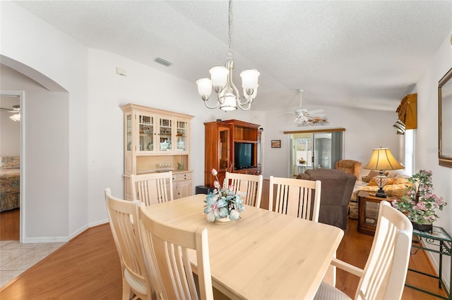1202 San Bernardo Rd, The Villages, FL 32162 - dining area with arched walkways, visible vents, vaulted ceiling, and ceiling fan with notable chandelier