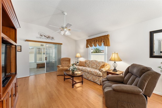 1202 San Bernardo Rd, The Villages, FL 32162 - living area featuring a ceiling fan, light wood-type flooring, vaulted ceiling, and a textured ceiling