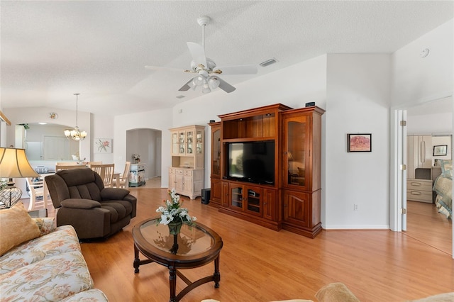 1202 San Bernardo Rd, The Villages, FL 32162 - living room featuring arched walkways, a textured ceiling, visible vents, vaulted ceiling, and light wood finished floors
