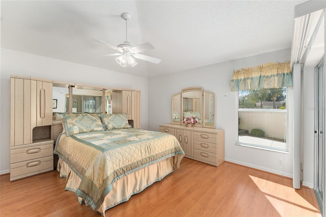 1202 San Bernardo Rd, The Villages, FL 32162 - bedroom featuring light wood-style flooring, baseboards, ceiling fan, and a textured ceiling