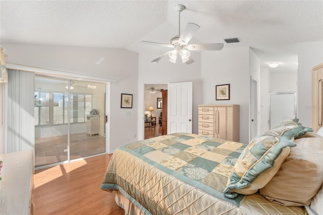 1202 San Bernardo Rd, The Villages, FL 32162 - bedroom with lofted ceiling, visible vents, a textured ceiling, wood finished floors, and access to outside