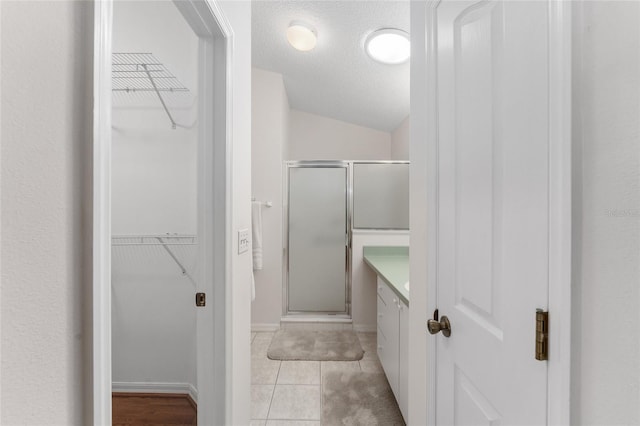 1202 San Bernardo Rd, The Villages, FL 32162 - full bathroom with a shower stall, a walk in closet, a textured ceiling, and vanity
