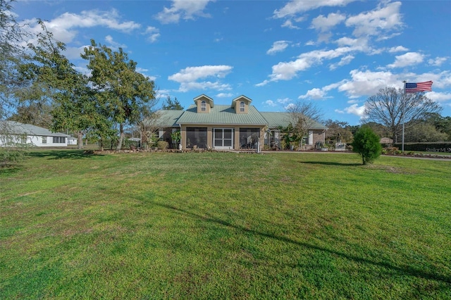 view of front of property featuring metal roof and a front yard