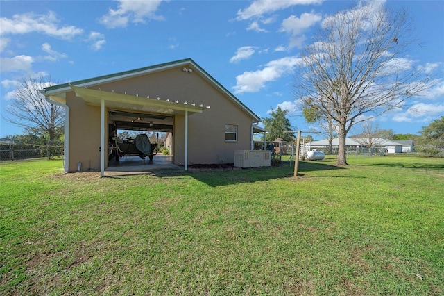 rear view of property featuring a yard, a patio, and stucco siding