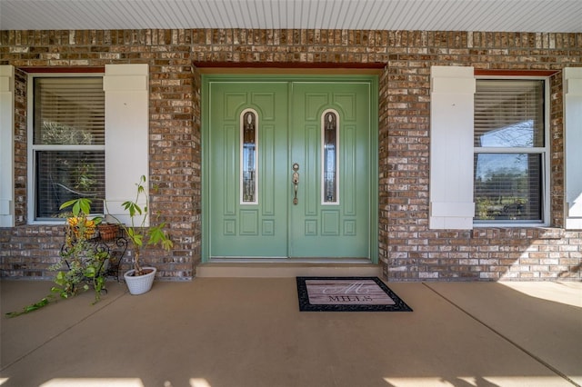 view of exterior entry featuring brick siding