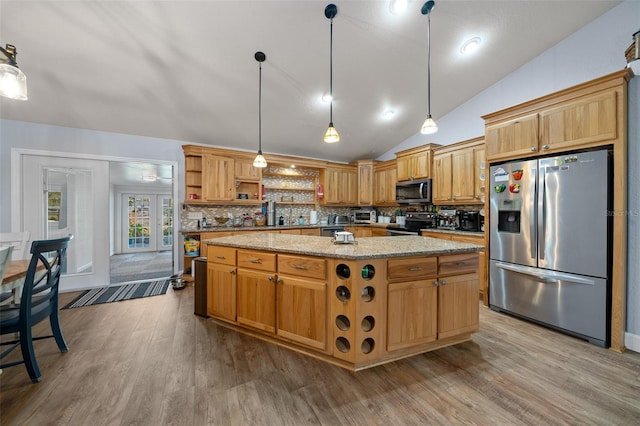 kitchen with appliances with stainless steel finishes, wood finished floors, vaulted ceiling, open shelves, and backsplash