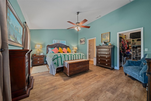 bedroom with visible vents, lofted ceiling, wood finished floors, a spacious closet, and a closet