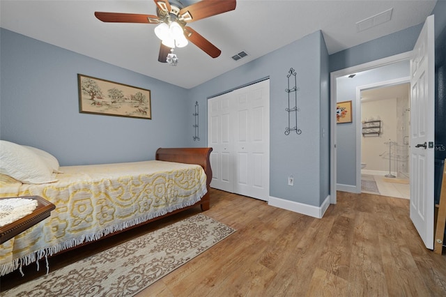 bedroom with baseboards, a closet, visible vents, and wood finished floors