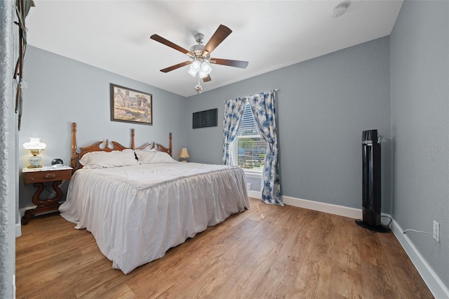 bedroom with light wood-style floors, ceiling fan, and baseboards