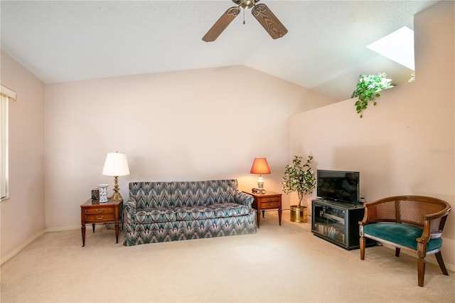 living room with carpet floors, vaulted ceiling with skylight, baseboards, and a ceiling fan