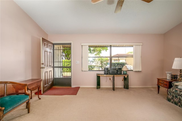 living area with ceiling fan, carpet flooring, and baseboards