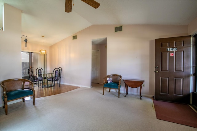 living area with carpet floors, visible vents, vaulted ceiling, and ceiling fan with notable chandelier