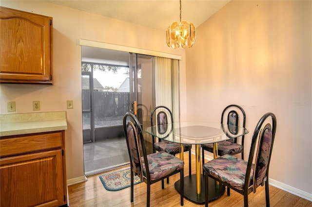 dining space with a chandelier, light wood-type flooring, and baseboards