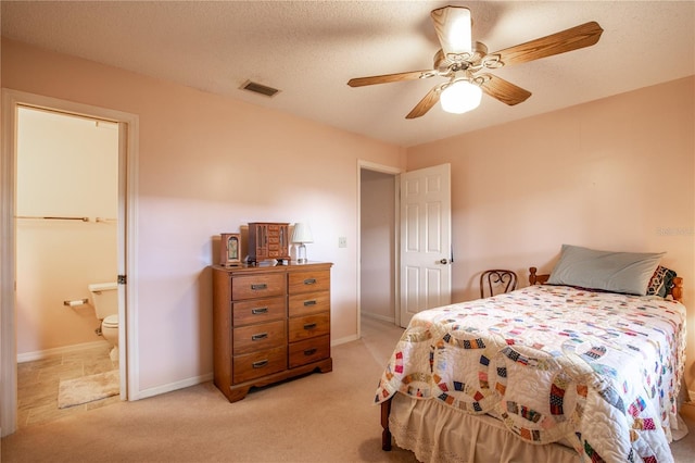 bedroom featuring a textured ceiling, connected bathroom, light carpet, visible vents, and baseboards