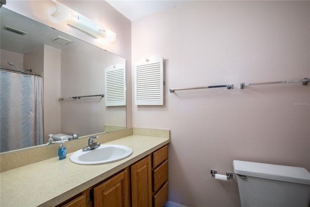 bathroom with toilet, visible vents, and vanity