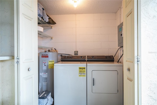 laundry area with concrete block wall, washer and clothes dryer, electric water heater, a textured ceiling, and laundry area