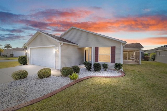 ranch-style house featuring roof with shingles, a front yard, a sunroom, a garage, and driveway