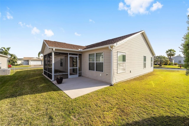 rear view of house featuring a patio, a lawn, and a sunroom