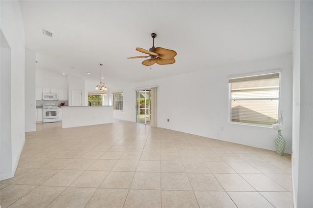 unfurnished living room featuring vaulted ceiling, light tile patterned floors, ceiling fan with notable chandelier, and a healthy amount of sunlight