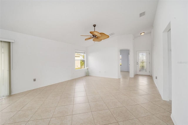 unfurnished room featuring a wealth of natural light, visible vents, ceiling fan, and light tile patterned flooring