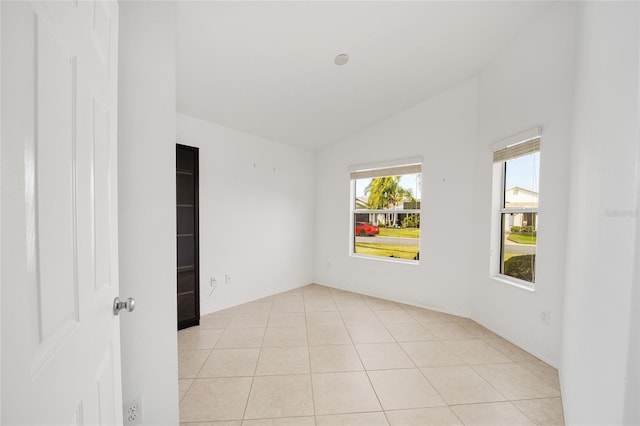 unfurnished room featuring vaulted ceiling and light tile patterned flooring