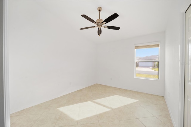 empty room with a ceiling fan and light tile patterned floors