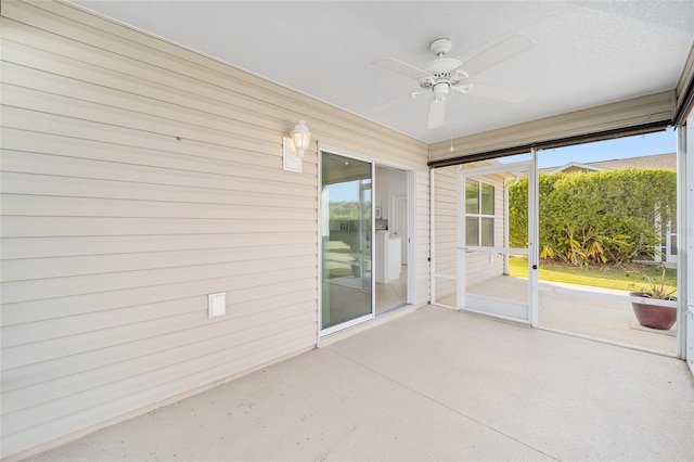 unfurnished sunroom featuring a ceiling fan