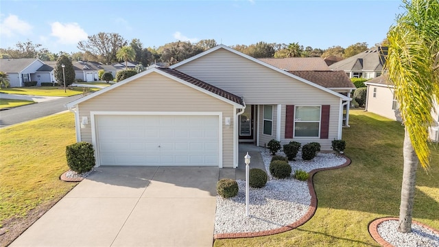 view of front of property featuring a front yard, driveway, a residential view, and an attached garage