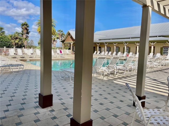 pool with a patio area and fence