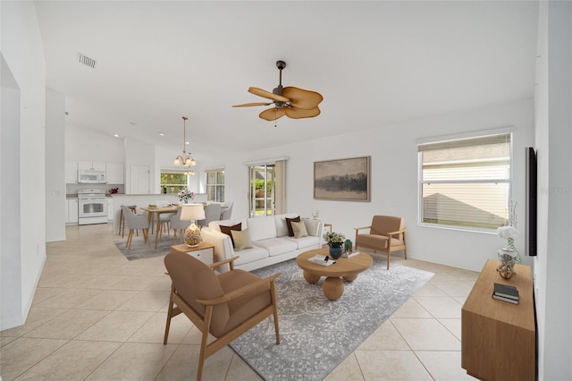 living area featuring light tile patterned floors, plenty of natural light, visible vents, and vaulted ceiling