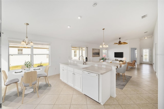 kitchen featuring light tile patterned flooring, a sink, visible vents, light countertops, and dishwasher