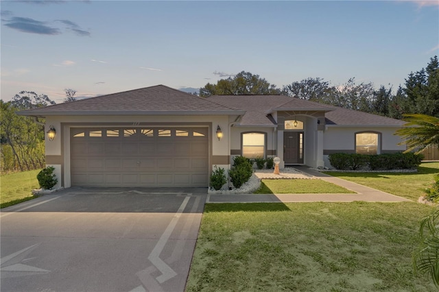 prairie-style house featuring a front yard, concrete driveway, and stucco siding