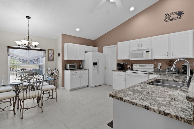 kitchen featuring stone counters, white appliances, a sink, white cabinets, and hanging light fixtures