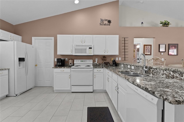 kitchen with a peninsula, white appliances, white cabinetry, and a sink