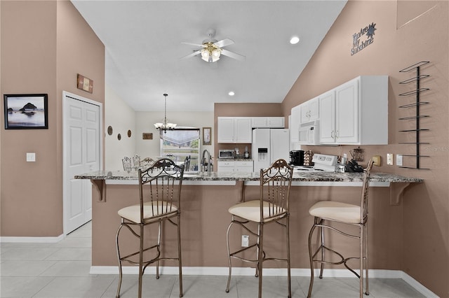 kitchen featuring light stone counters, a breakfast bar, and white appliances