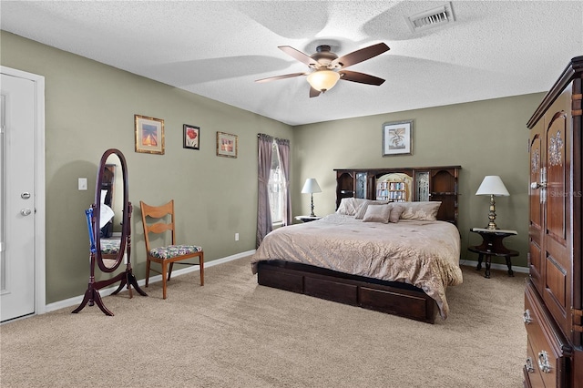 bedroom with baseboards, visible vents, light colored carpet, ceiling fan, and a textured ceiling