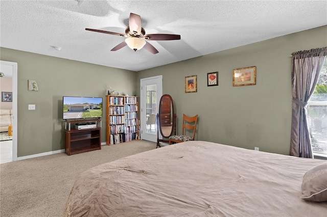 carpeted bedroom featuring ceiling fan, a textured ceiling, and baseboards