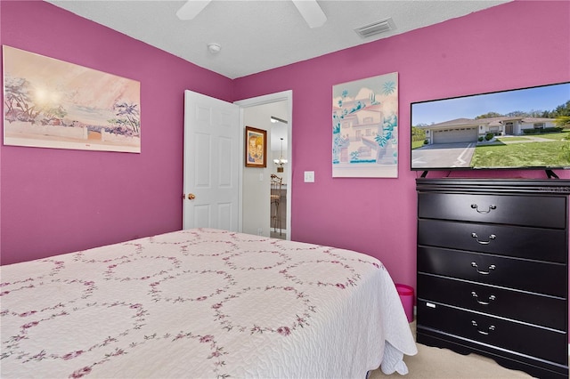 bedroom featuring a textured ceiling, carpet flooring, visible vents, and a ceiling fan