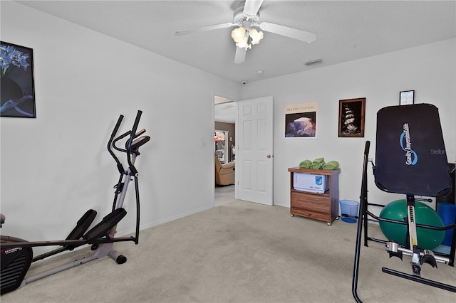 exercise area with baseboards, visible vents, ceiling fan, a textured ceiling, and carpet floors