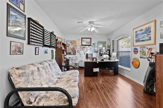 home office with a textured ceiling, wood finished floors, visible vents, a ceiling fan, and baseboards