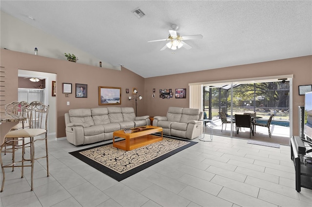 living room with lofted ceiling, a textured ceiling, visible vents, and a ceiling fan