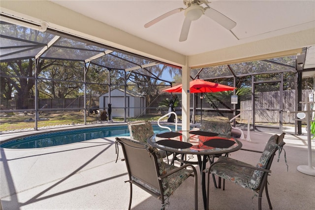 view of pool with a storage shed, glass enclosure, a fenced backyard, an outdoor structure, and a patio area