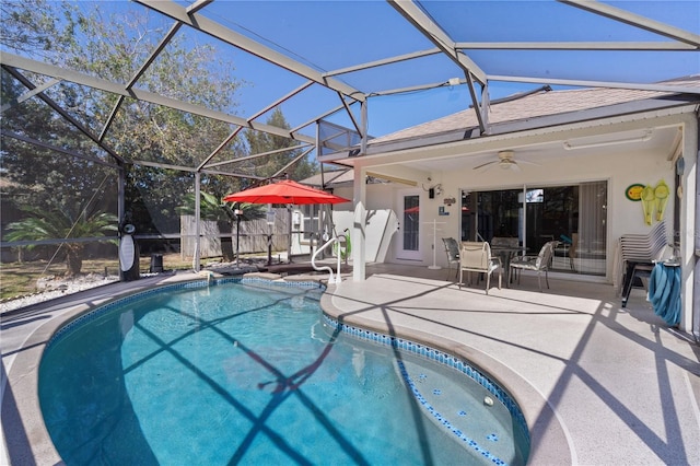 pool with a ceiling fan, glass enclosure, and a patio area